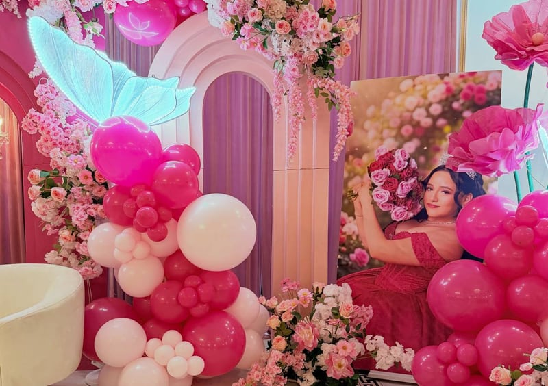 Hot pink and white balloon column with an illuminated butterfly and florals beside a large framed portrait panel